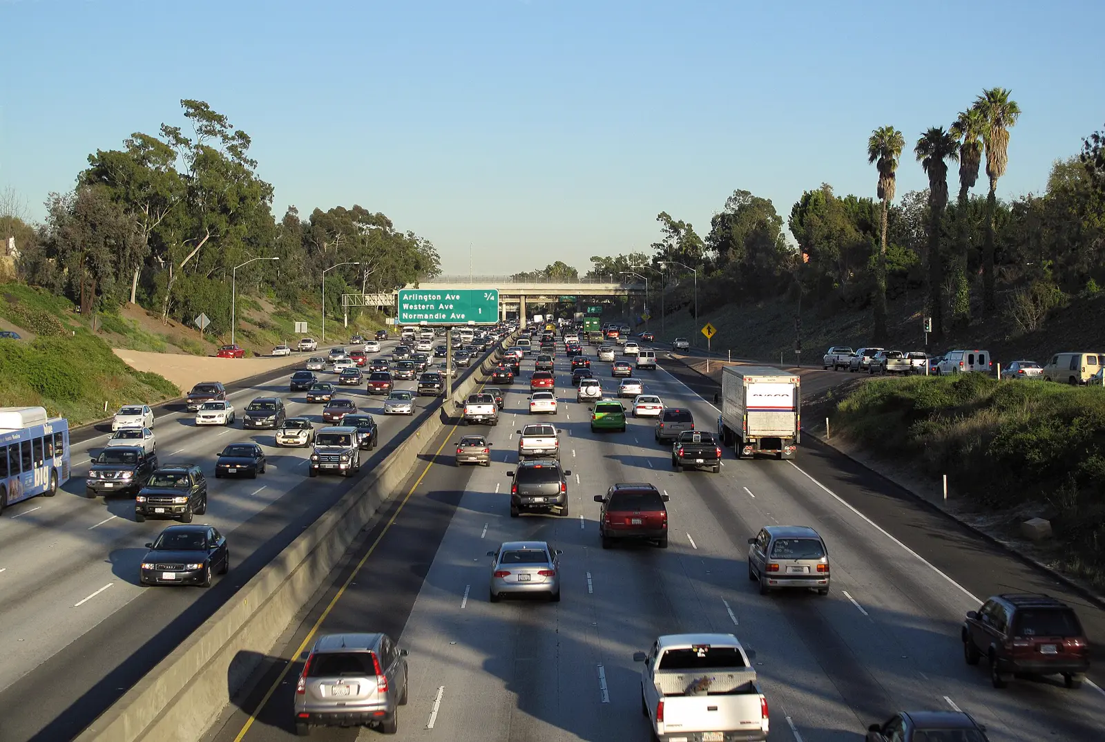 Interstate 10 in Los Angeles, eight lanes of traffic heading east past palm trees